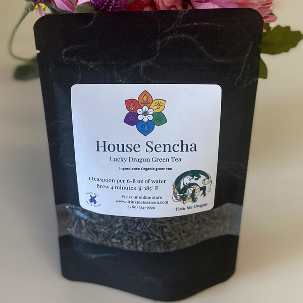 Black tea package with 'House Sencha' label against a floral background